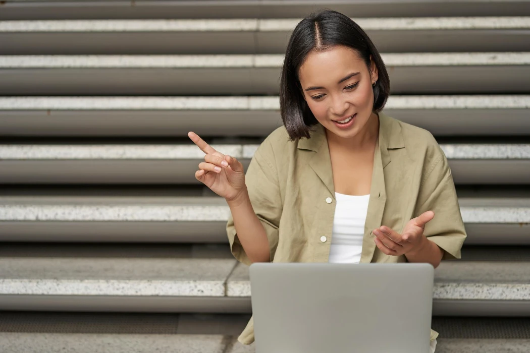 Portrait of young asian girl student talks at laptop video chat speaking during online meeting sitti